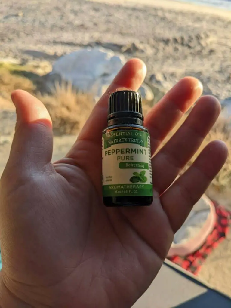 Bottle of Peppermint Pure Essential Oil On A Hand