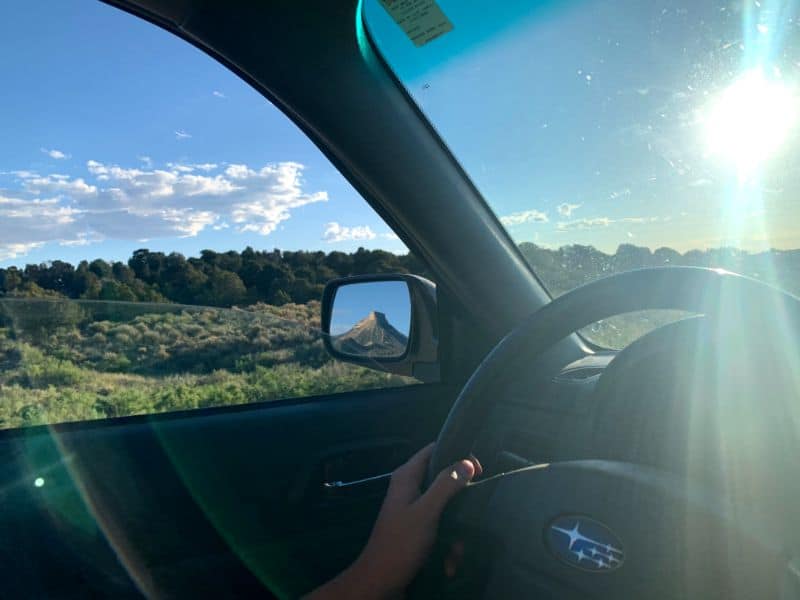 Driving On A Beautiful Sunny Day With A Mountain On The Rear View
