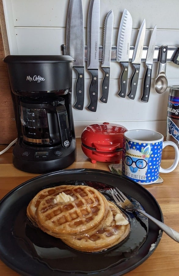 Electric Coffee Maker Next To A Plate Of Waffles