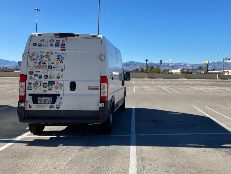 White-Van-With-Stickers-At-The-Back-On-The- Parking Lot