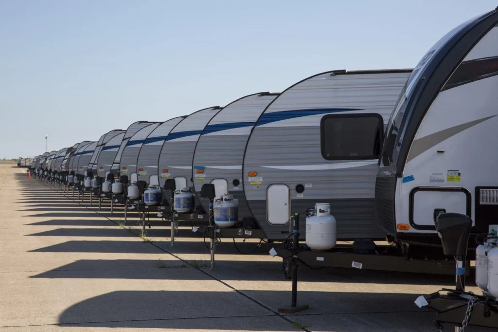 Lines of campers sitting at an RV dealership.